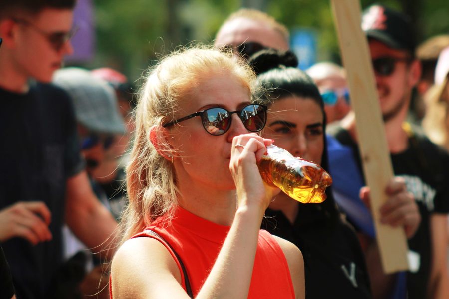 Blonde Girl Drinking Energy Drink in Demonstration